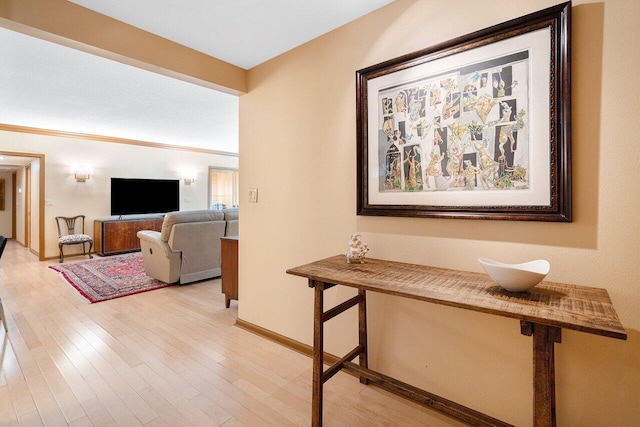 hall with hardwood / wood-style flooring and crown molding