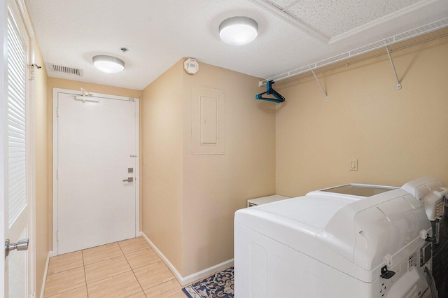 washroom with washer / dryer and light tile floors