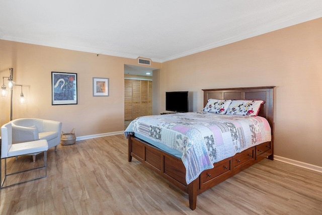 bedroom featuring wood-type flooring, crown molding, and a closet