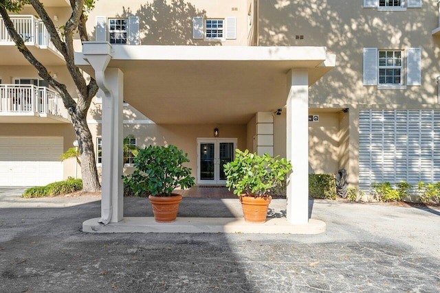 entrance to property featuring a garage and a balcony