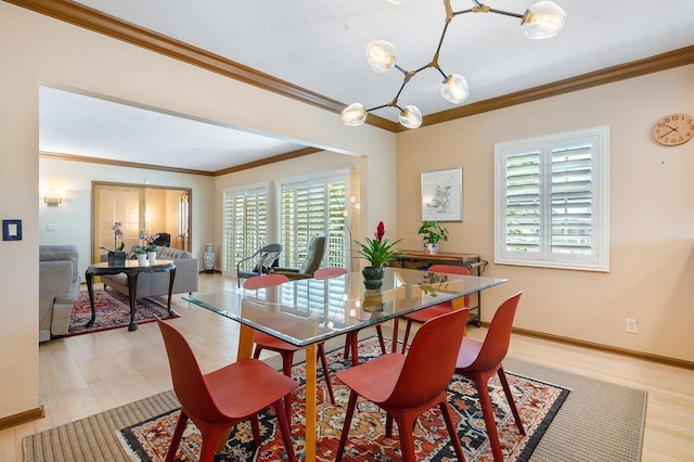 dining space with ornamental molding, a chandelier, and light wood-type flooring