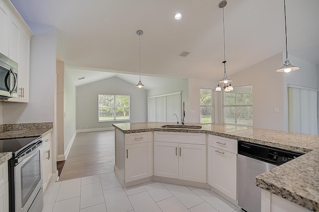 kitchen featuring hanging light fixtures, lofted ceiling, light tile flooring, stainless steel appliances, and white cabinets