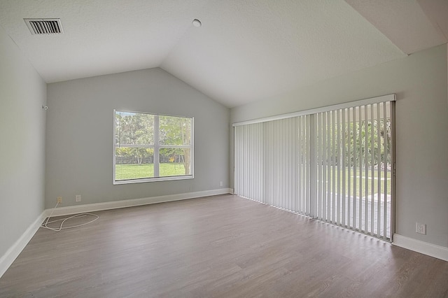 empty room with vaulted ceiling and light wood-type flooring