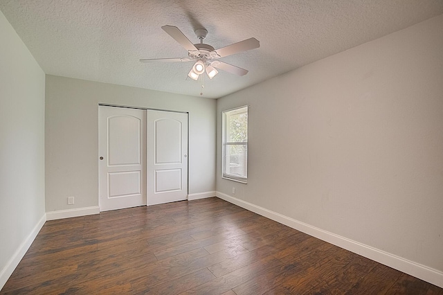 unfurnished bedroom with a textured ceiling, a closet, ceiling fan, and dark wood-type flooring