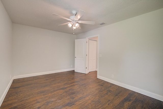 spare room with a textured ceiling, dark hardwood / wood-style floors, and ceiling fan