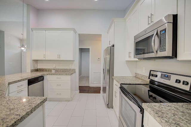 kitchen featuring pendant lighting, white cabinetry, appliances with stainless steel finishes, and light tile floors