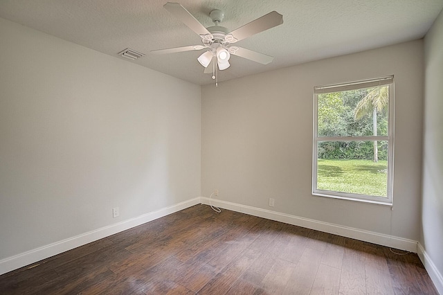 spare room featuring a textured ceiling, ceiling fan, dark hardwood / wood-style floors, and a wealth of natural light