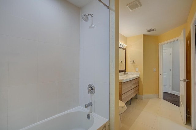 full bathroom featuring tile floors, oversized vanity, toilet, and tiled shower / bath