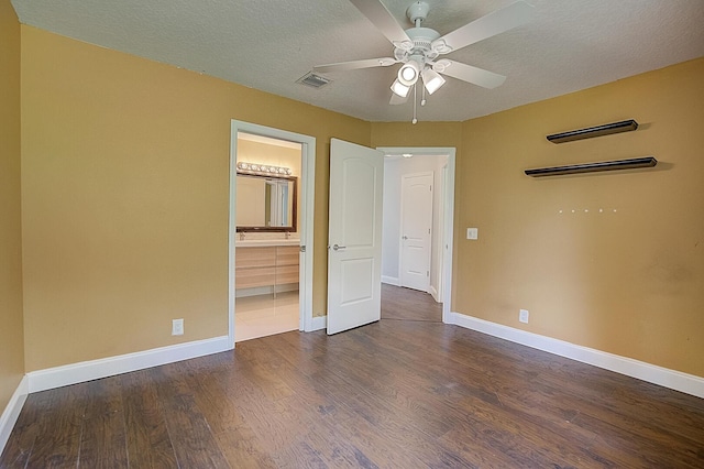 unfurnished bedroom featuring a textured ceiling, ensuite bath, ceiling fan, and dark hardwood / wood-style floors