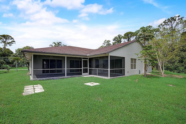 back of property with a sunroom and a lawn