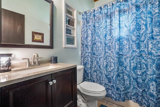 bathroom with toilet, tile floors, and vanity