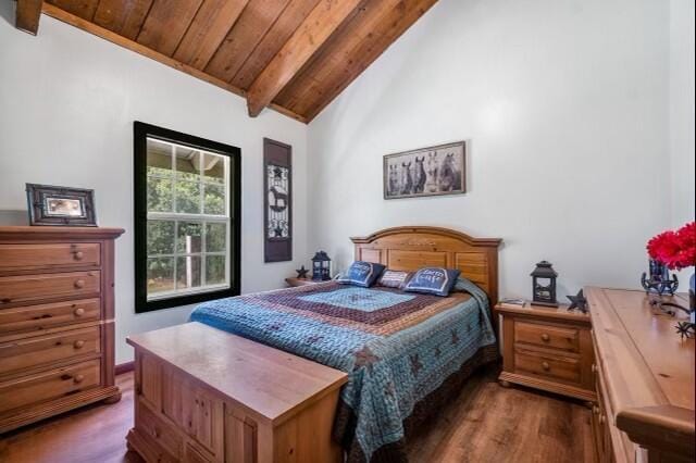 bedroom with wooden ceiling, dark wood-type flooring, high vaulted ceiling, and beam ceiling