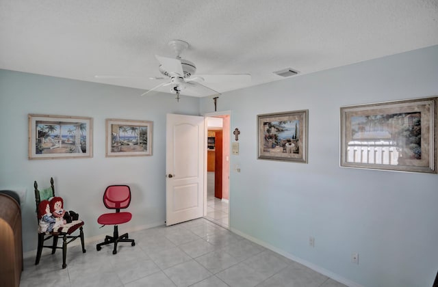 unfurnished room with a textured ceiling, ceiling fan, and light tile floors