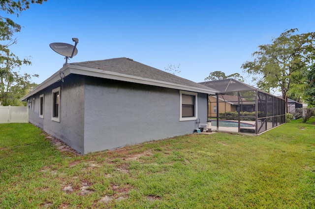 rear view of house featuring a fenced in pool, a yard, and glass enclosure