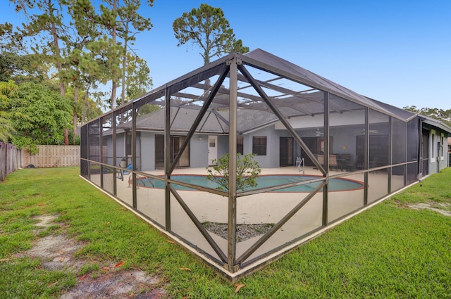 view of swimming pool with a yard, a patio, and a lanai