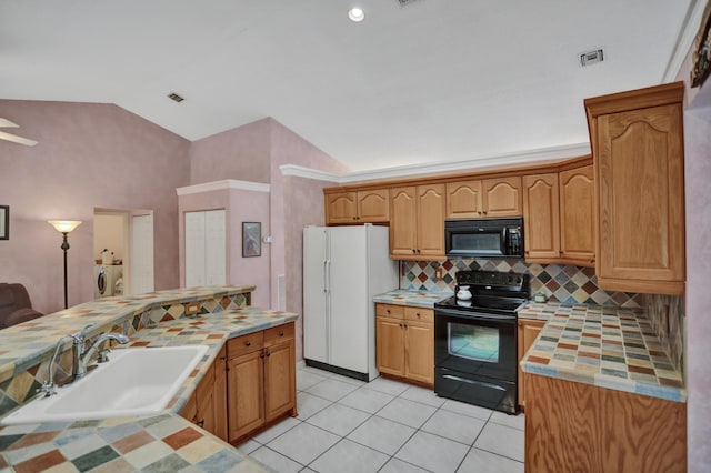 kitchen with tasteful backsplash, sink, light tile floors, black appliances, and washer / clothes dryer