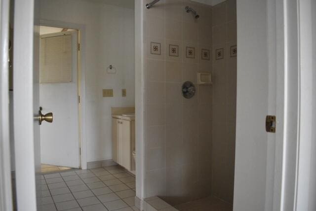 bathroom with a tile shower and tile flooring