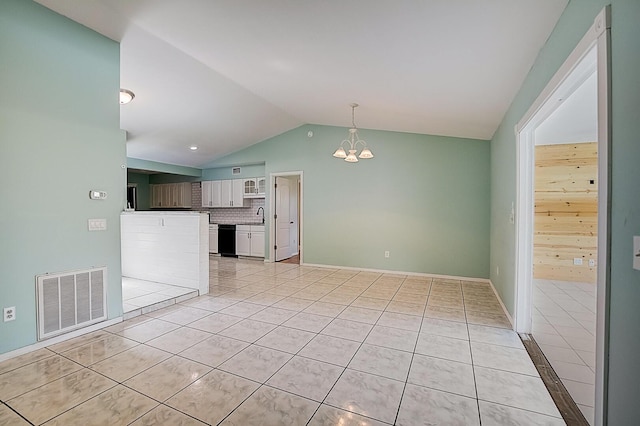 interior space with an inviting chandelier, vaulted ceiling, light tile floors, and sink