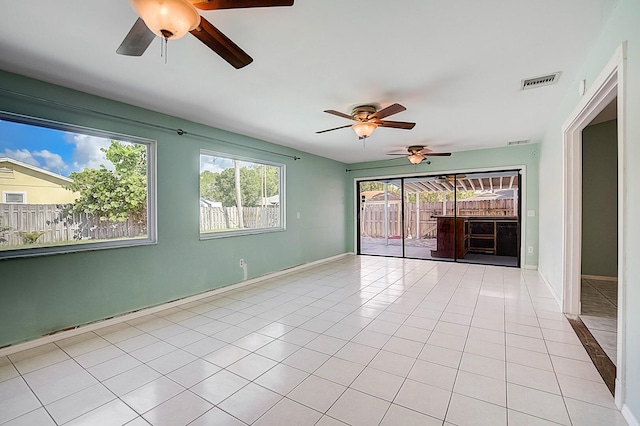 tiled spare room with ceiling fan