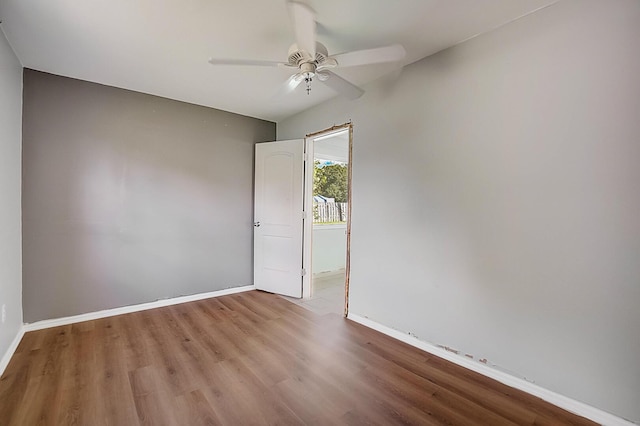 empty room with ceiling fan and hardwood / wood-style flooring