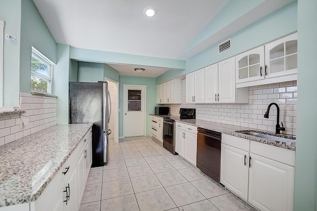 kitchen featuring white cabinets, backsplash, black dishwasher, and range with electric stovetop