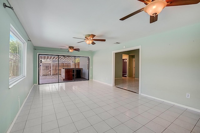 tiled spare room with ceiling fan