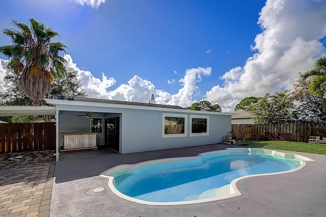 view of swimming pool featuring ceiling fan and a patio
