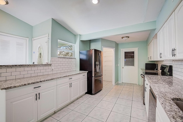kitchen with white cabinets, tasteful backsplash, light stone countertops, and stainless steel appliances