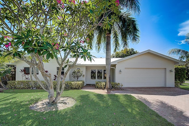 view of front of property featuring a front yard and a garage