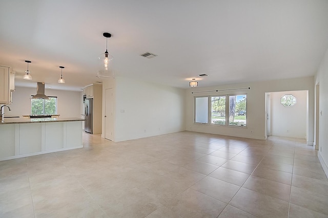 unfurnished living room featuring sink and light tile floors