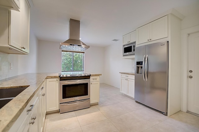 kitchen featuring kitchen peninsula, white cabinetry, appliances with stainless steel finishes, light tile floors, and wall chimney range hood