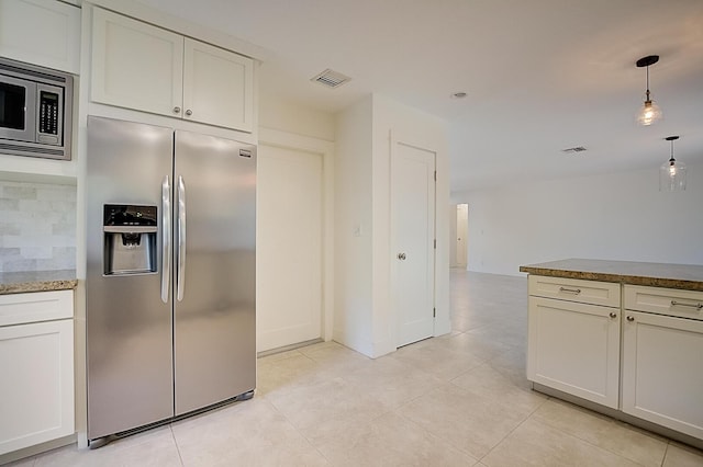 kitchen with backsplash, light tile flooring, appliances with stainless steel finishes, light stone counters, and pendant lighting