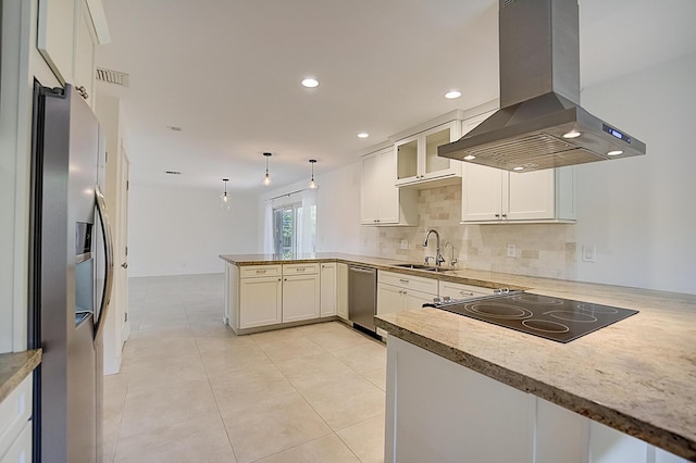 kitchen featuring kitchen peninsula, sink, island exhaust hood, hanging light fixtures, and backsplash