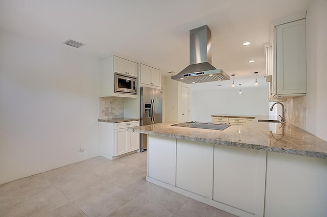 kitchen with island range hood, stainless steel appliances, light stone countertops, tasteful backsplash, and sink