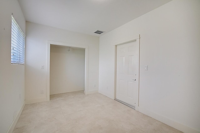 unfurnished bedroom featuring a closet and light tile floors