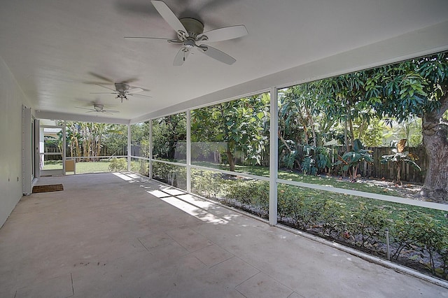 unfurnished sunroom featuring ceiling fan