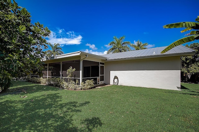 rear view of house with a sunroom and a lawn