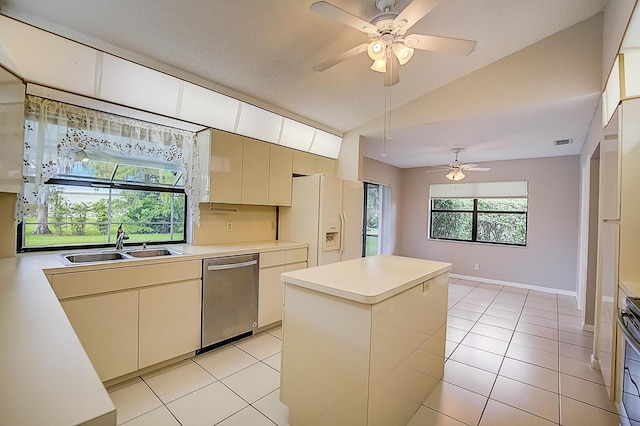 kitchen with light tile floors, appliances with stainless steel finishes, a kitchen island, and ceiling fan