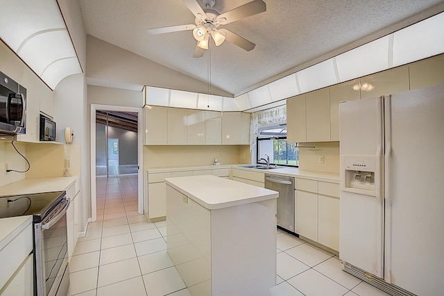 kitchen with ceiling fan, stainless steel appliances, light tile flooring, vaulted ceiling, and a center island