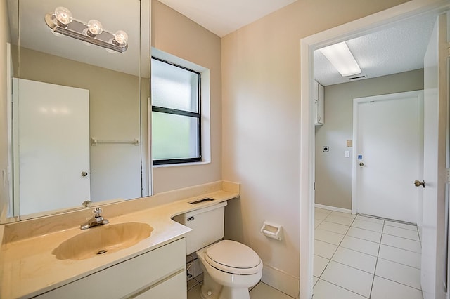 bathroom with vanity, a textured ceiling, tile floors, and toilet