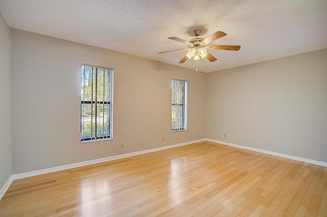 empty room featuring a textured ceiling, ceiling fan, and light wood-type flooring