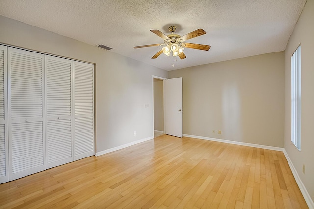 unfurnished bedroom featuring a closet, a textured ceiling, ceiling fan, and light hardwood / wood-style flooring