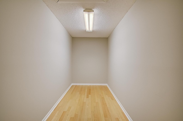 spare room with a textured ceiling and light hardwood / wood-style flooring