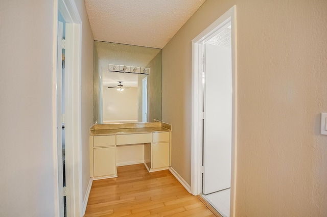 corridor featuring a textured ceiling and light hardwood / wood-style flooring