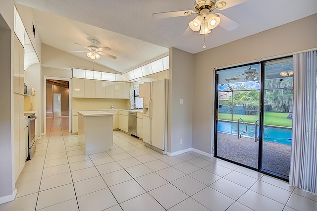 kitchen with lofted ceiling, light tile floors, ceiling fan, white refrigerator with ice dispenser, and dishwasher