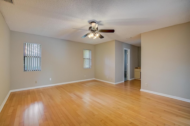 empty room with a textured ceiling, ceiling fan, and light hardwood / wood-style flooring