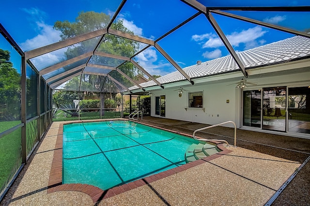 view of swimming pool featuring a patio, ceiling fan, and glass enclosure