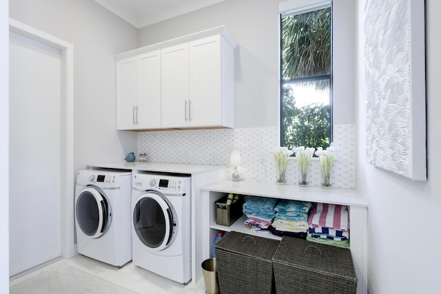 laundry room featuring washer and dryer, cabinets, and light tile floors