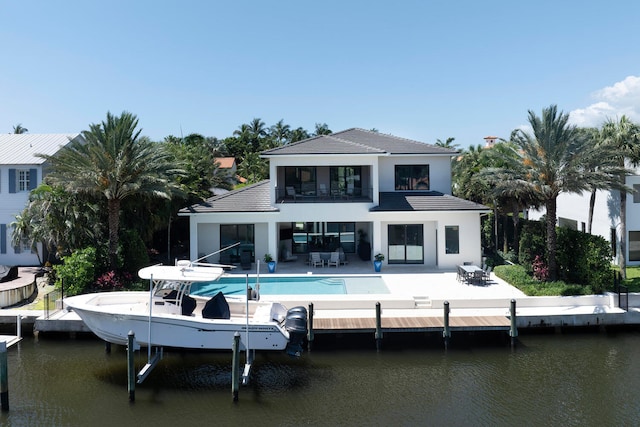 rear view of property featuring a water view and a patio area