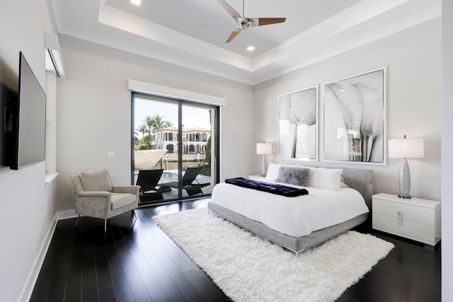 bedroom with a tray ceiling, ceiling fan, dark hardwood / wood-style flooring, and access to outside